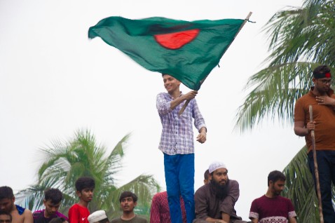 A happy boy waves the Bangladesh flag